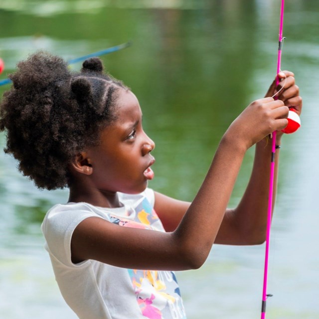 Kid preparing a fishing rod